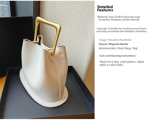 Detail view of cream leather bucket bag with square gold handle and branding tags