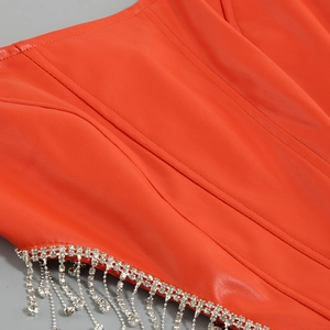 Vue détaillée du corset en cuir rouge avec des finitions à franges en strass brillants