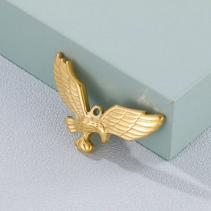 Polished golden eagle pendant with spreading wings leaning on a blue gift display box