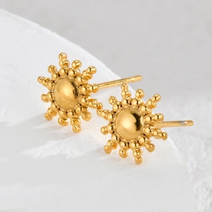 18K gold plated stainless steel sunburst stud earrings on a white stone base
