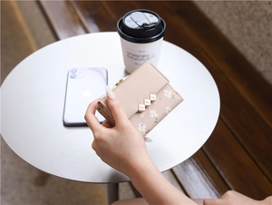 Detail of floral print tri-fold mini wallet in beige PU leather with metal leaf buckle