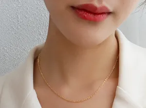 Goldene feine Halskette mit Evil Eye Anhänger, am Modelhals in Nahaufnahme gezeigt