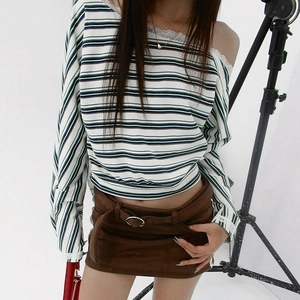 Detail of striped off-shoulder top with white lace trim and brown suede mini skirt