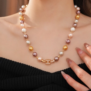 Detail of multi-color pearl necklace with gold zirconia-set square buckle on a model