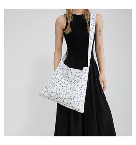 Detail of floral canvas crossbody bag with lilac flower print and wide strap