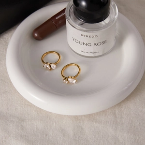 Détail de bagues en acier titane doré avec zircons en forme de poire et de marquise