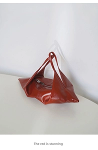 Detail of the reddish-brown oil wax leather bag with double handles and metal zipper