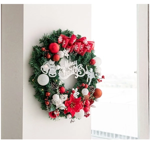 Détail de couronne de Noël avec inscription Merry Christmas, nœud rouge et pommes