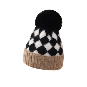 Infant winter knit hat with black and white checkerboard pattern and faux fur pompom