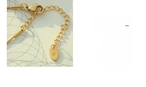 Detail of 18K gold plated necklace showing lobster clasp and engraved K18 metal tag