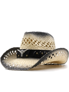 Detail of hollow woven straw cowboy hat with bull head emblem and vintage black gradient brim