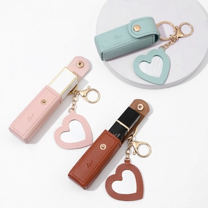 Close-up of mini PU leather lipstick cases with heart mirrors in pink, brown, and green