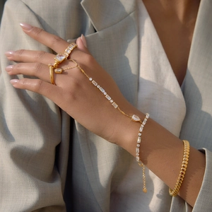 Detail of gold-plated finger bracelet with marquise zircon stones on model's hand