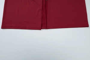 Detail of side slit hem on a red sleeveless dress with high-quality double stitching