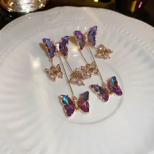 Sparkling butterfly tassel earrings with gradient wings and crystals on a white plate