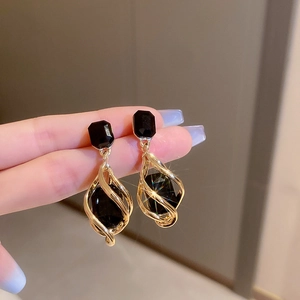 Macro shot of vintage style earrings with black faceted gemstones and golden metal details