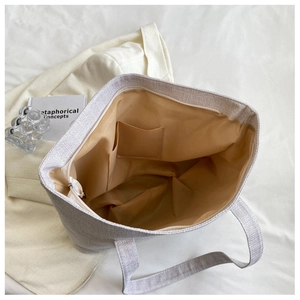 Detail view of large tote bag interior showing beige lining and spacious storage