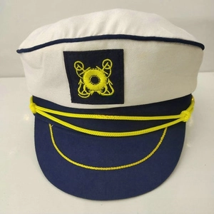 Close-up of white and blue captain hat featuring yellow anchor embroidery and braided cord