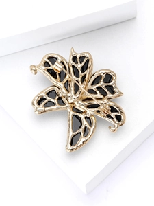 Macro shot of the pin and clasp mechanism on the back of the golden lily brooch