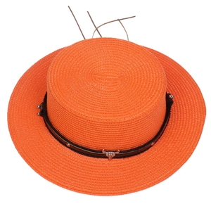 Top view of orange straw boater hat with black leather band and metal bull skull charm