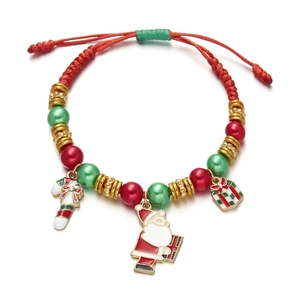 Macro detail of red woven Christmas bracelet with Santa and candy cane charms
