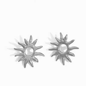 Detailed close-up of silver sun-shaped stud earrings in polished stainless steel
