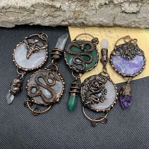 Vintage bronze wrapped round crystal pendants with snake, skull, and dragon motifs