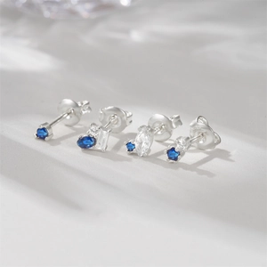 Detail view of 925 silver stud earrings set with blue opal and moon star geometric shapes
