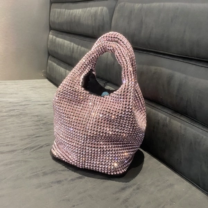 Close-up of sparkling pink rhinestone bucket bag on textured dark grey background