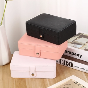 Three-tier stack of leather jewelry organizers in black, pink, and blush with snap closure