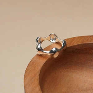 Minimalist 925 sterling silver geometric wavy ring on rustic wood background