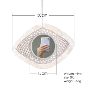 Detail of eye-shaped woven wall mirror measuring 38cm width with 15cm glass diameter