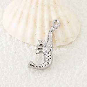 Macro d'un pendentif homard en acier inoxydable sur coquillage pour bijoux DIY