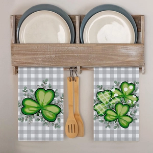 Hanging kitchen towels with green shamrock pattern on grey checkered background