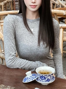 Détail du haut en tricot gris ajusté à manches longues montrant la texture douce