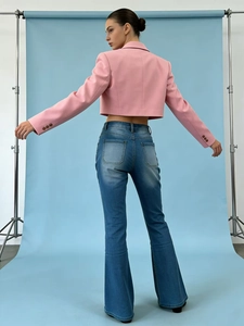Vue arrière d'un blazer rose à manches longues avec un jean bleu à taille haute évasé