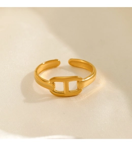 Makro-Detailaufnahme des goldenen Schweinenasen-Rings auf beigem Samt-Hintergrund