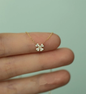 Macro shot of 925 silver 14k gold four-leaf clover pendant with pavé diamonds necklace
