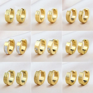 Close-up of nine pairs of gold geometric huggie earrings with textured and crystal details