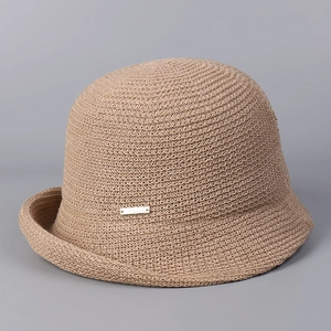 Close-up of lightweight linen knit bucket hat with breathable texture and gold brand plate