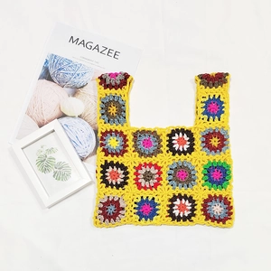 Detail of colorful patchwork crochet handbag with vibrant flower patterns and cotton texture