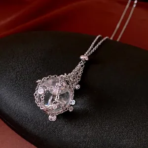 Elegant silver necklace featuring a transparent crystal ball pendant with rhinestone mesh wrap