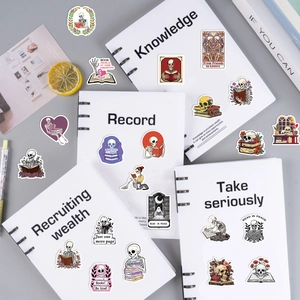Flat lay of gothic skull book stickers on a notebook with various creative designs