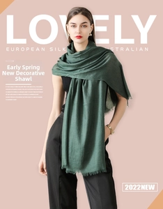 Close-up of deep green solid color silk shawl with delicate tassel edge details