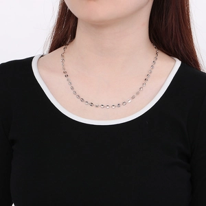 Detail of silver oval link necklace on neck showing elegant metal texture and fit