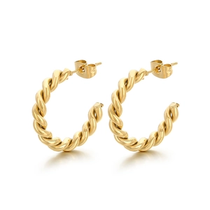 Paire de boucles d'oreilles créoles torsadées en acier inoxydable doré sur fond blanc
