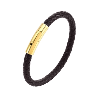 Bracelet en cuir noir tressé avec fermoir magnétique en acier inoxydable doré sur fond blanc