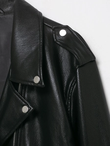 Detail shot of black leather biker jacket with silver metallic snaps and textured lapel