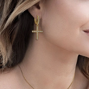 Chic gold-plated cross earrings with sparkling zircon stones worn by a model