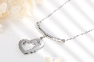 Close-up of silver heart necklace with sparkling gemstones on a clean white backdrop
